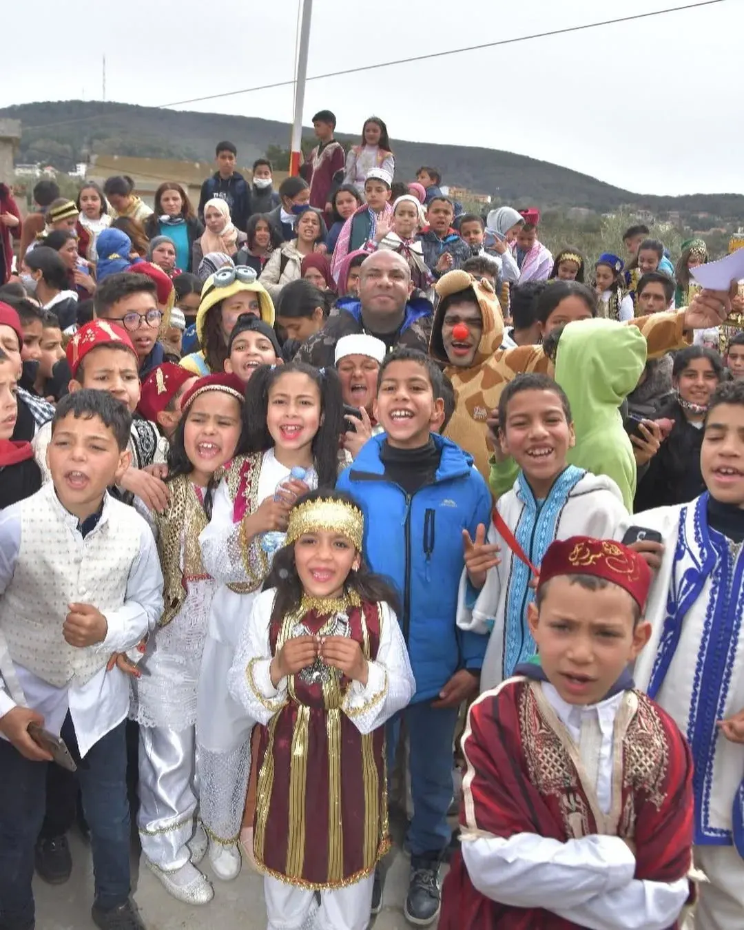 Enfants rassemblés autour de Karim Gharbi